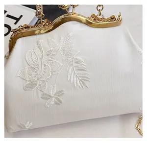 Macro shot of embroidered floral texture and vintage metal clasp on evening bag