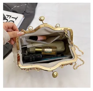 Detail view of the spacious inner compartment of the pearl evening bag with gold clasp