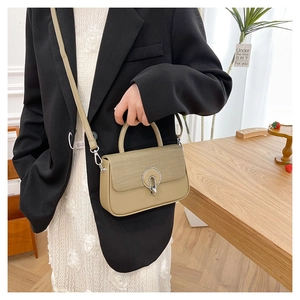 Detail view of khaki green box bag with silver ring buckle and textured flap design