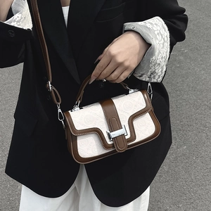 Elegante borsa a tracolla beige goffrata con bordo marrone e fibbia argento sul modello