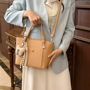 Sac seau minimaliste en cuir marron avec breloque ours et bandoulière amovible