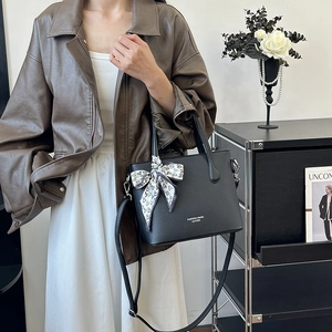 Sac seau chic en cuir grainé noir avec poignée en soie et bandoulière réglable