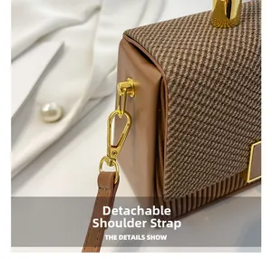 Detail of detachable shoulder strap with gold hardware on a brown box bag