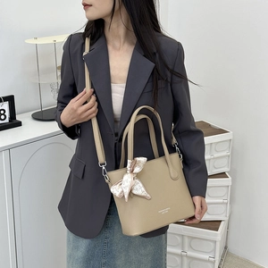 Sac seau élégant en cuir beige avec foulard en soie, poignées et bandoulière ajustable