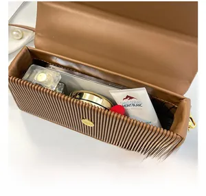 Interior view of brown leather box bag showing capacity for perfume and cosmetics