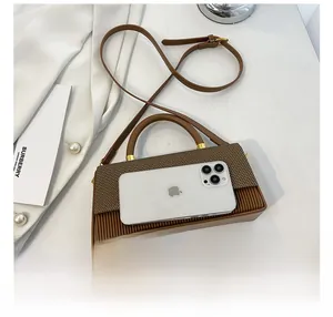 Brown box bag size comparison with smartphone showing woven texture and pleated detail