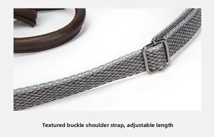 Detail of adjustable gray textured shoulder strap with dark metal buckle and tassel