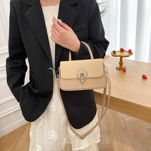 Chic beige woven leather crossbody bag with metal ring buckle shown in a lifestyle setting