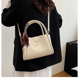 Dettaglio borsa a secchiello bianco panna con grana litchi e foulard in seta decorativo