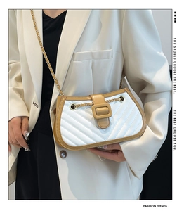 Quilted color-block crossbody bag with gold chain strap shown on a model