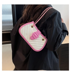 Detail of pink and white quilted crossbody bag featuring chain strap and square buckle