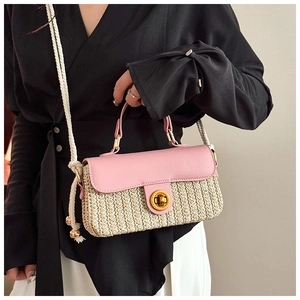 Dettaglio borsa a tracolla in paglia rosa e beige con chiusura dorata e tracolla in corda