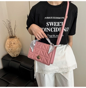 Pink quilted shoulder bag detail with gold clasp and silk scarf wrapped handle
