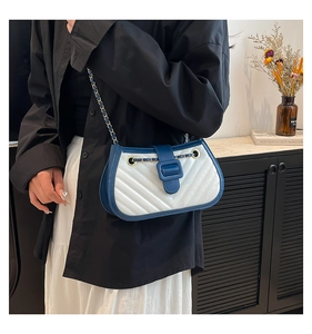 Detail of blue and white quilted leather crossbody bag with golden chain strap
