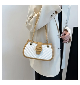 Close-up of quilted leather handbag with khaki flap and gold chain strap detailing