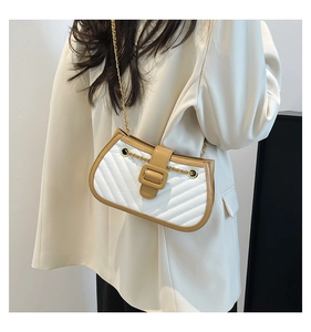 Quilted diamond pattern crossbody bag with brown trim and gold chain shown on a model