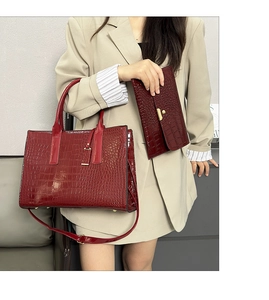 Macro detail of the wine red crocodile texture tote bag and matching clutch set
