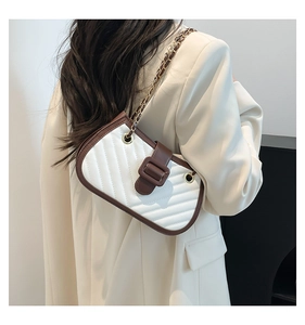 Close-up of quilted chain bag with contrast stitching and golden hardware detail