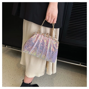 Close-up of sparkling iridescent sequin fabric and floral gold metal frame of a shell clutch
