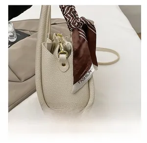 Dettaglio borsa a secchiello in pelle martellata bianco crema con foulard di seta sul manico