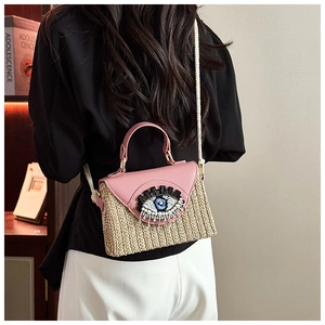 Dettaglio borsa di paglia con occhio di perline e patta in pelle rosa con tracolla a corda