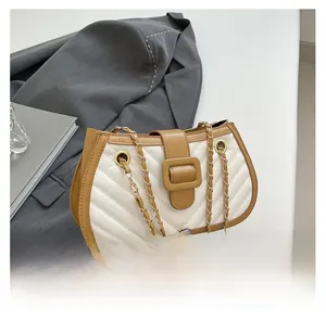 Detail of quilted leather crossbody bag with chain strap and contrast binding detail