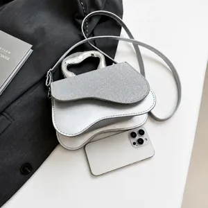 Detail der silbernen Satteltasche mit Metallgriff und gewebter Textur auf dem Deckel