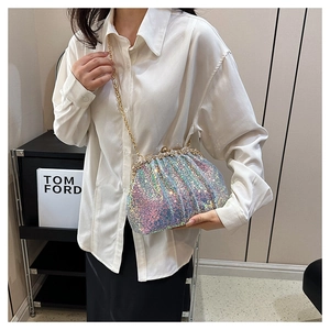 Close-up of shell-shaped bag with iridescent sequins, rhinestone lock, and gold chain