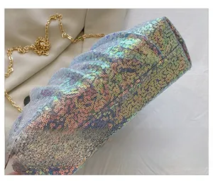 Detail showing colorful sequins on a pleated evening clutch with golden chain strap