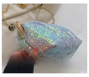 Detail of iridescent sequin shell bag featuring vintage floral gold metal clasp and chain