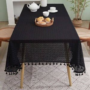 Detail of black cotton linen tablecloth featuring retro geometric hollow patterns and tassels