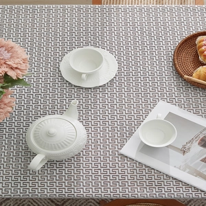 Rectangular white lace tablecloth with Greek key patterns and elegant afternoon tea setting