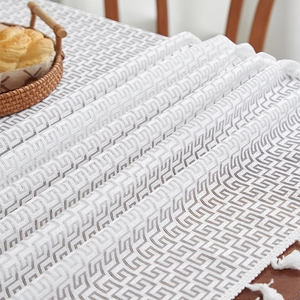 Detailed view of white rectangular lace tablecloth with Greek key pattern and soft fringes