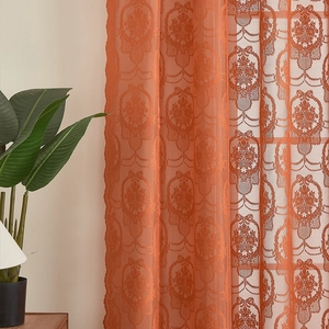 Detail of orange lace curtain showing damascus floral patterns and bow elements