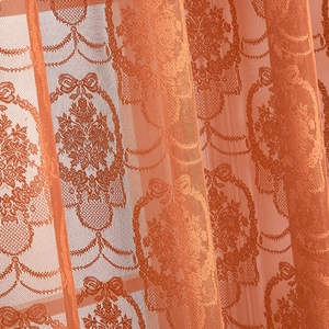 Detailed macro view of orange French lace curtain with butterfly jacquard pattern