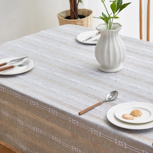 Close-up of retro hollow lace linen tablecloth with gray stripes and white embroidery