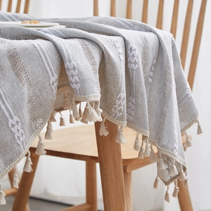 Detailed view of striped linen tablecloth with leaf embroidery and fringe tassels