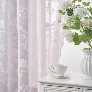 Close-up of soft pink lace curtain with elegant rose floral embroidery details