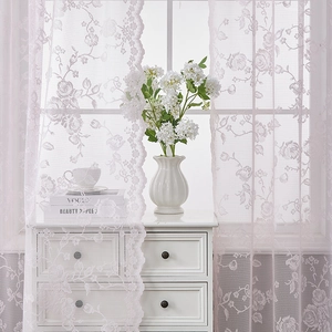 Detail of pink French lace curtain featuring delicate rose embroidery and wavy scallop edge