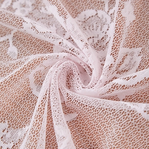 Detailed close-up of light pink lace fabric with intricate rose patterns and mesh texture