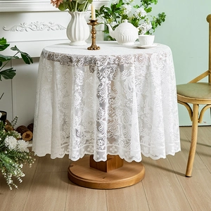 Detail of white French lace round tablecloth with ruffled edges and floral patterns