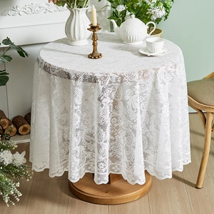 Detailed close-up of intricate white lace floral patterns and elegant ruffled edges on a tablecloth