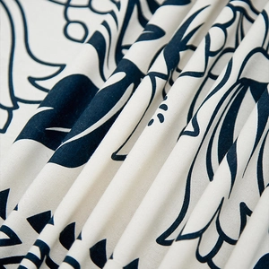 Detailed close-up of linen-blend tablecloth fabric with black floral mandala prints