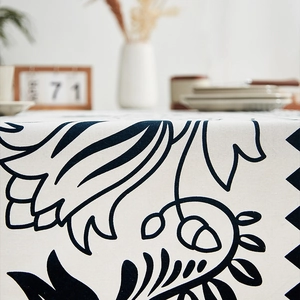 Detail of linen tablecloth with black floral patterns and high-quality fabric texture