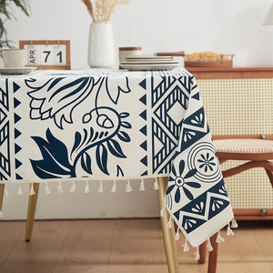 Detail of linen tablecloth with navy botanical floral print and white tassel edges