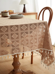 Detail showing bohemian hollow lace tablecloth with diamond pattern and white tassels