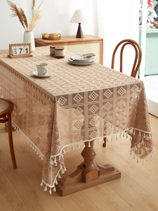 Detailed view of rectangle hollow lace tablecloth with geometric patterns and white tassels
