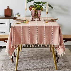 Detail of dusty pink cotton linen tablecloth with white embroidery and fringe