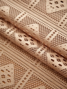 Macro shot of apricot lace tablecloth showing hollow crochet floral pattern and texture