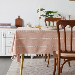 Rectangle orange-pink woven tablecloth with white geometric patterns and tassel edges